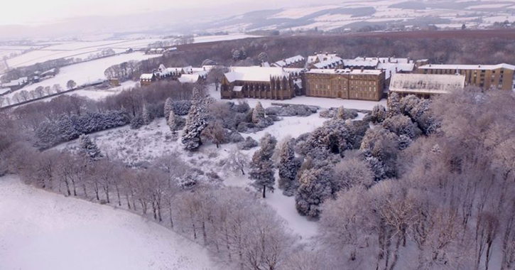 aerial shot of Ushaw historic house, chapels and garden covered in snow